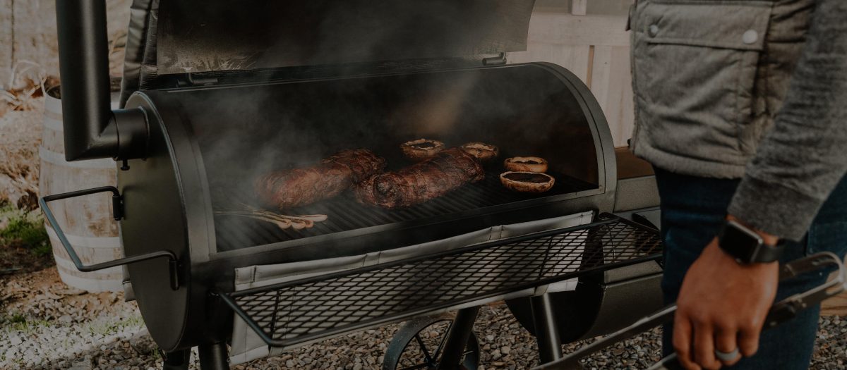 Large steel offset smoker in an outdoor cooking environment